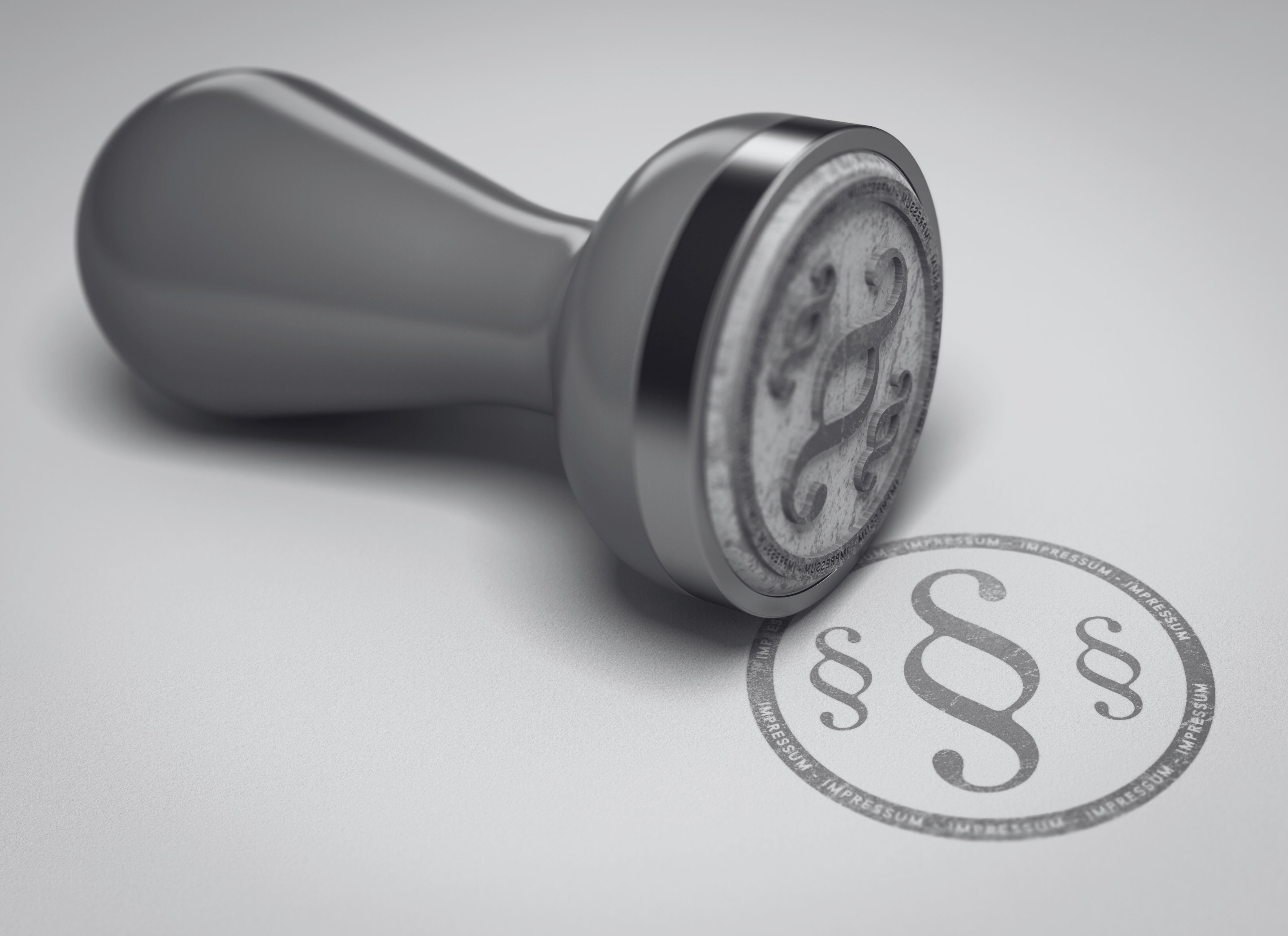 Rechtliche Sicherheit bei YOUL: Ein symbolischer Metallstempel druckt ein Paragrafenzeichen für den Bereich Impressum und gesetzliche Compliance.