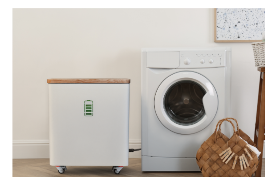 Der kompakte YOUL ONE Batteriespeicher im direkten Größenvergleich neben einer herkömmlichen Waschmaschine zur Veranschaulichung der platzsparenden Maße.