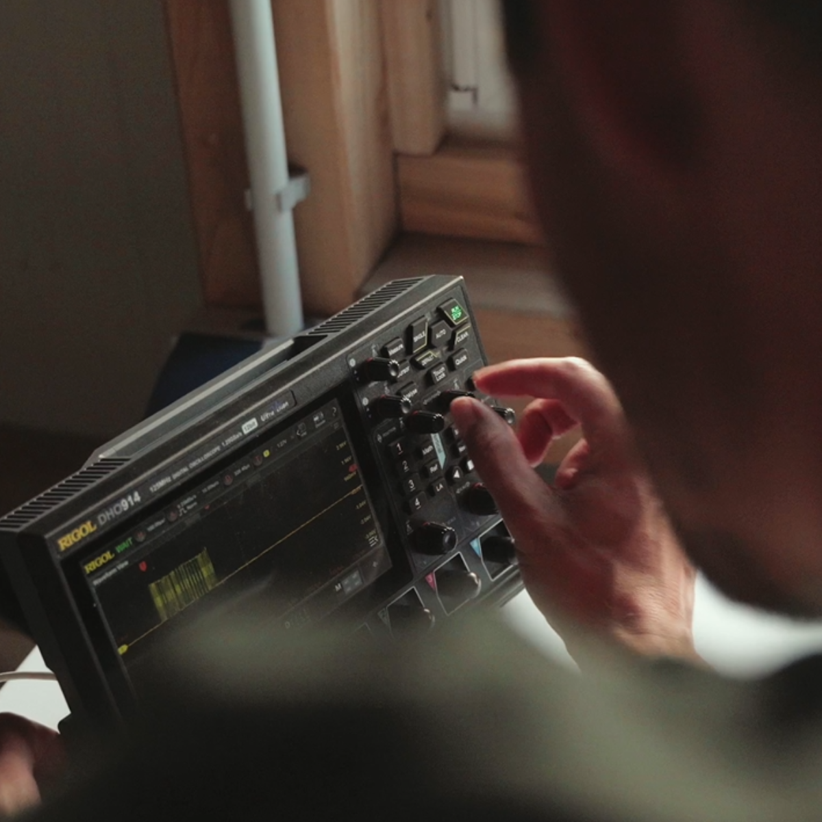 Sorgfältige Prüfung der Elektronik: Ein YOUL-Experte nutzt ein digitales Oszilloskop zur Feinabstimmung und Qualitätskontrolle der internen Komponenten des YOUL ONE Batteriespeichers.